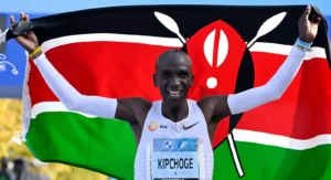 Eiud Kipchoge holding Kenyan Flag as he celebrates Berlin Marathon victory in 2022