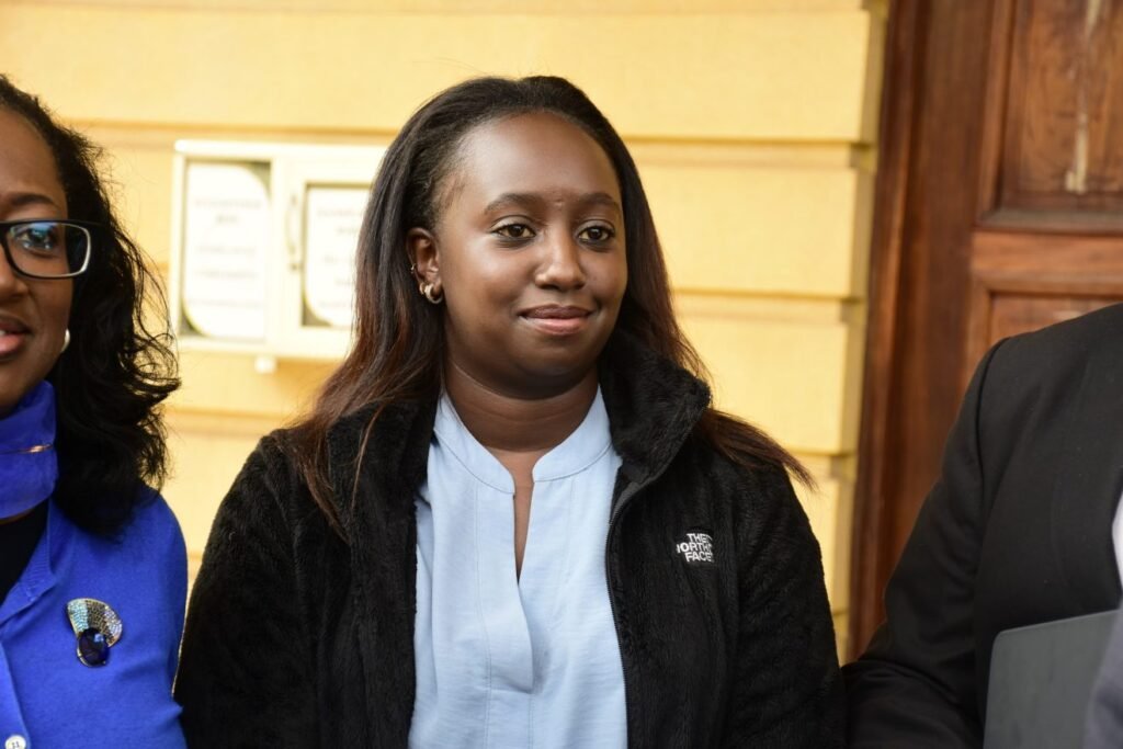 Kenyan rally driver Maxine Wahome standing outside court in a black fleece jacket.
