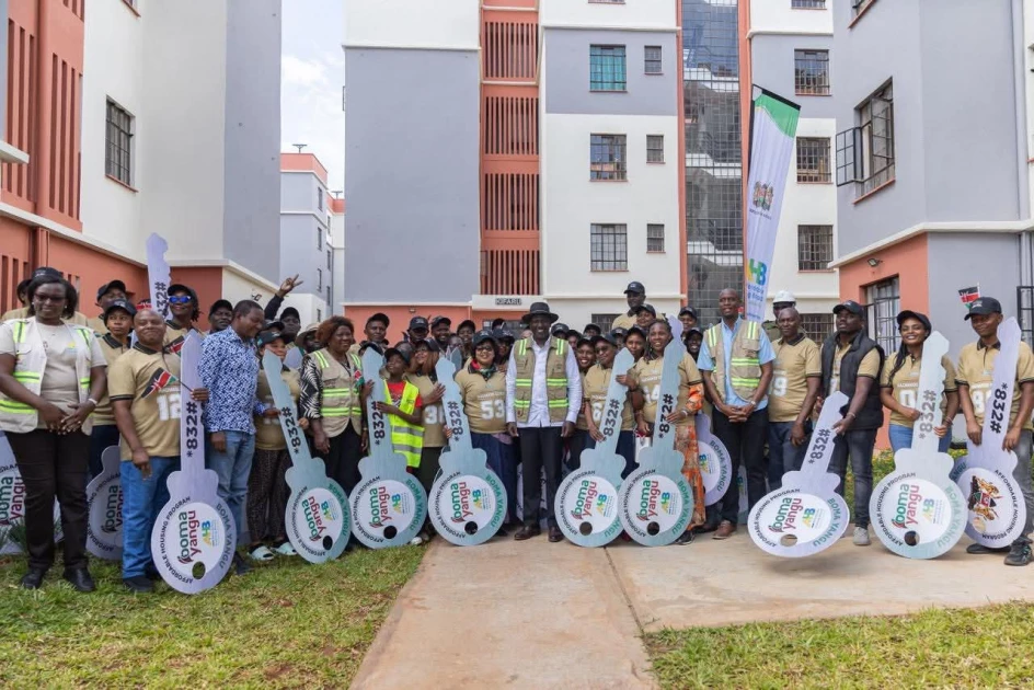 President William Ruto and beneficiaries holding oversized key props in front of completed Boma Yangu affordable housing units.