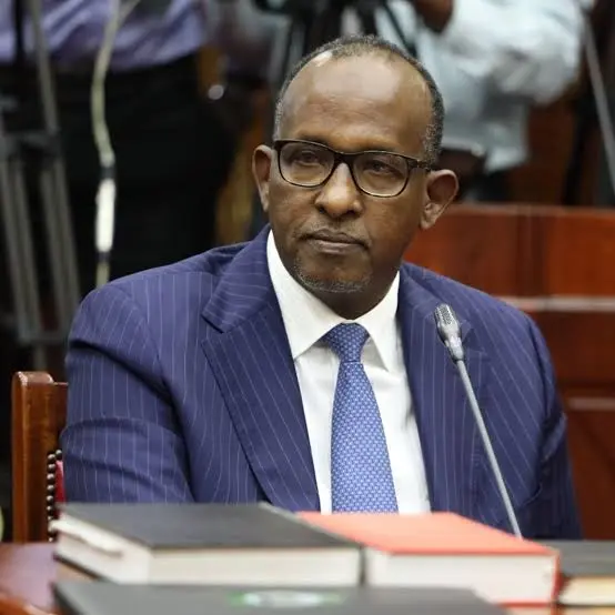 Kenyan Cabinet Secretary Aden Duale appearing before Parliament’s Committee on Appointments for vetting in August 2024, dressed in a blue pinstripe suit, blue patterned tie, and glasses.
