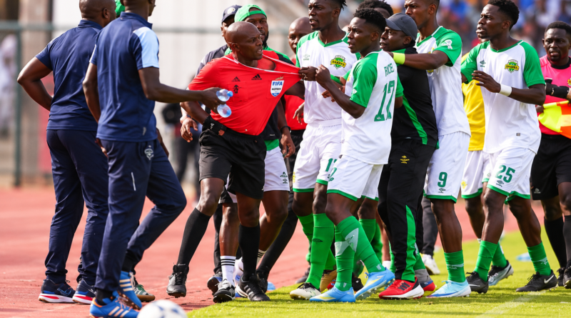 Kariobangi Sharks players and match officials in a chaotic confrontation on the touchline.