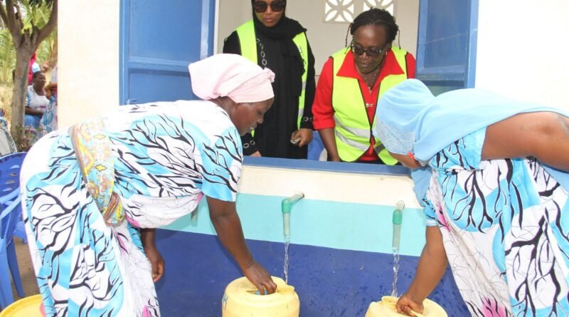 Women filling yellow jerrycans at a water collection point in Mombasa