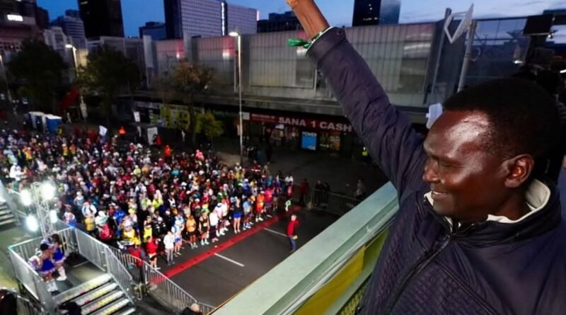 Paul Tergat raises a starting pistol above runners in Cape Town at the Nelson Mandela Marathon
