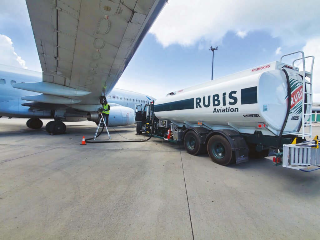 Rubis Aviation tanker refuelling a commercial aircraft at an airport.